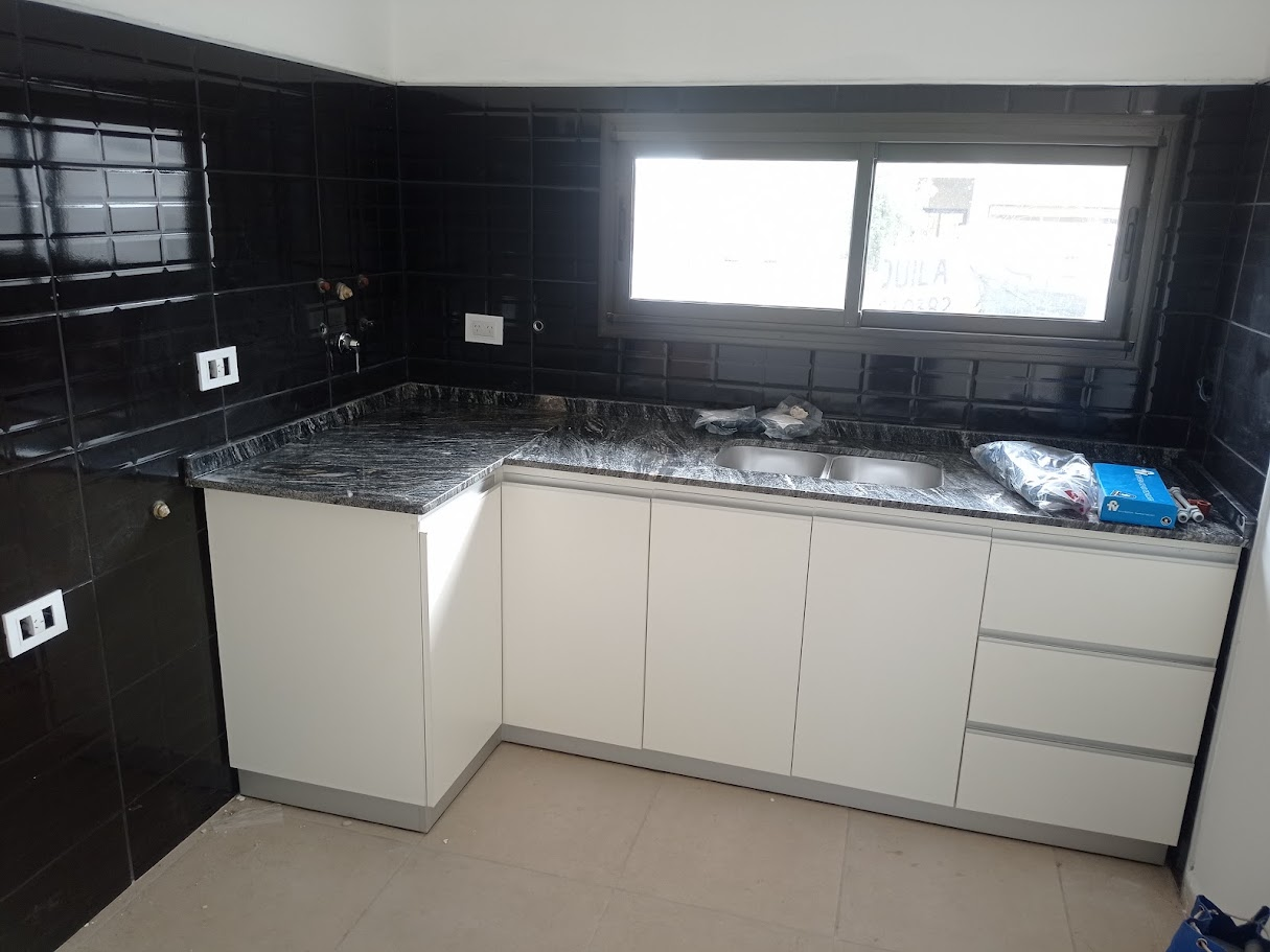 Cocina con mesada de mármol oscuro y azulejos negros