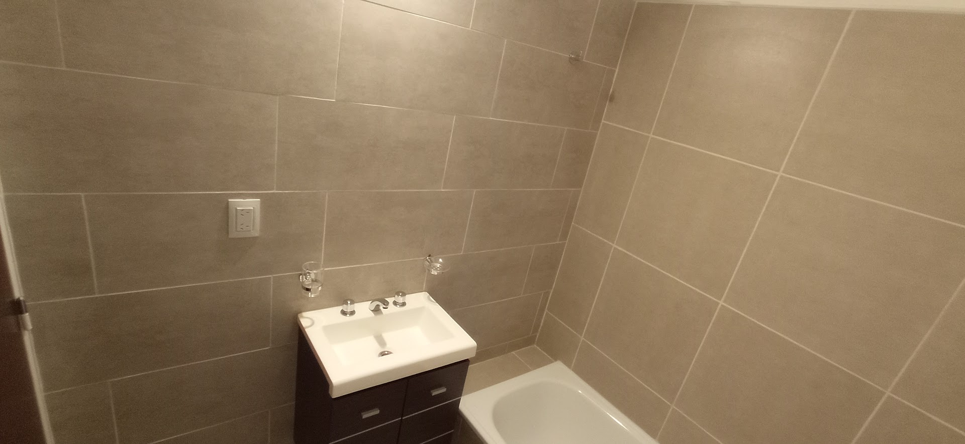 Baño con vanitory de madera y pileta blanca